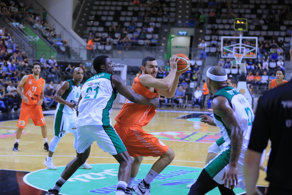 עידן זלמנסון ממכבי ראשון לציון מול הגנת מכבי חיפה ברוממה.